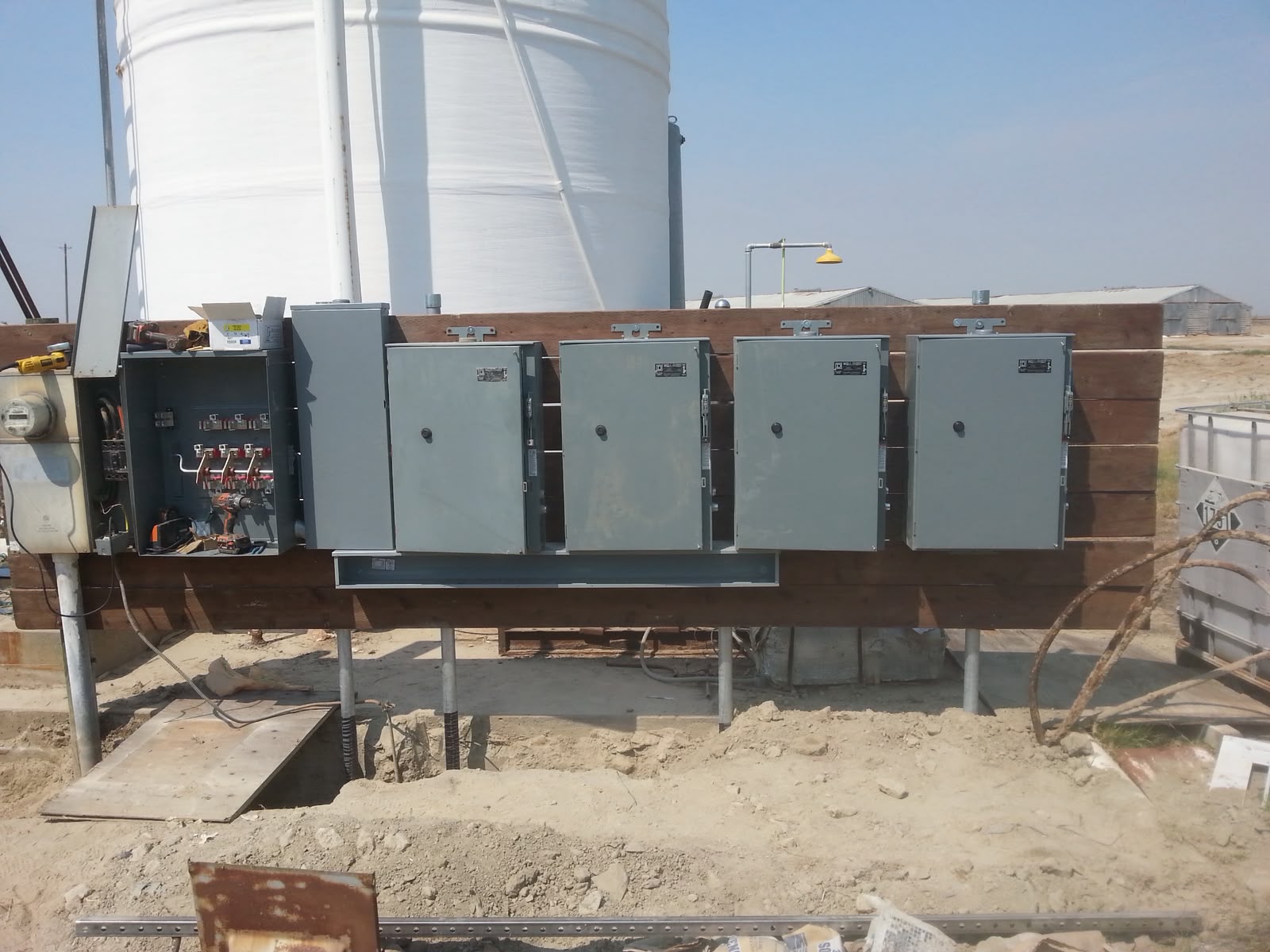 Row of agricultural service disconnects installed on redwood rack