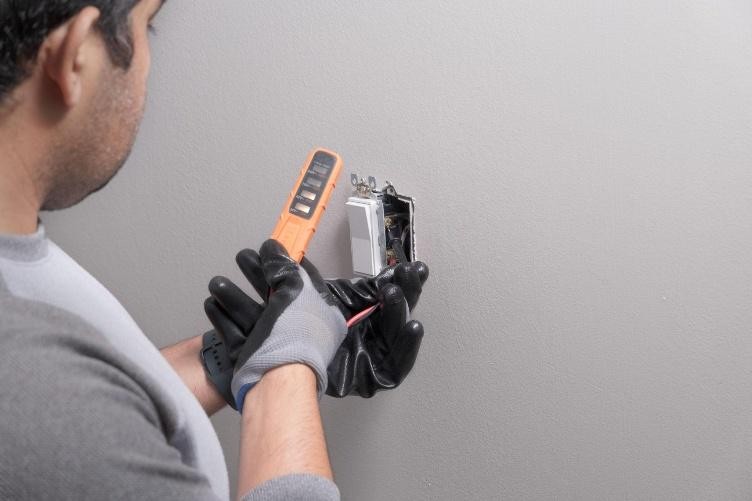 Electrician completing electrical switch installation in Central Valley on a residential wall.