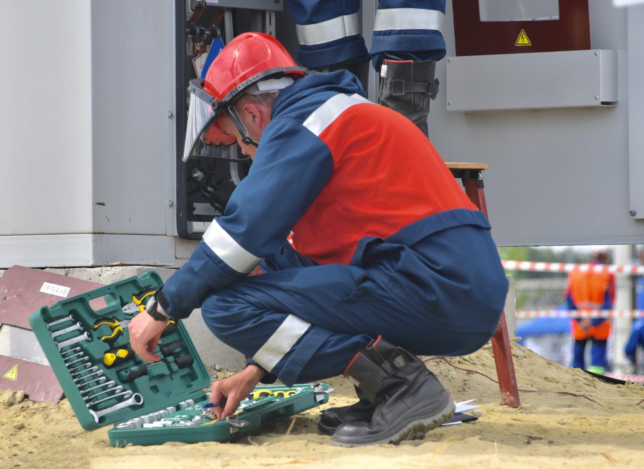 An electrician inspecting equipment and performing repairs as an electrical repair contractor in Central Valley.